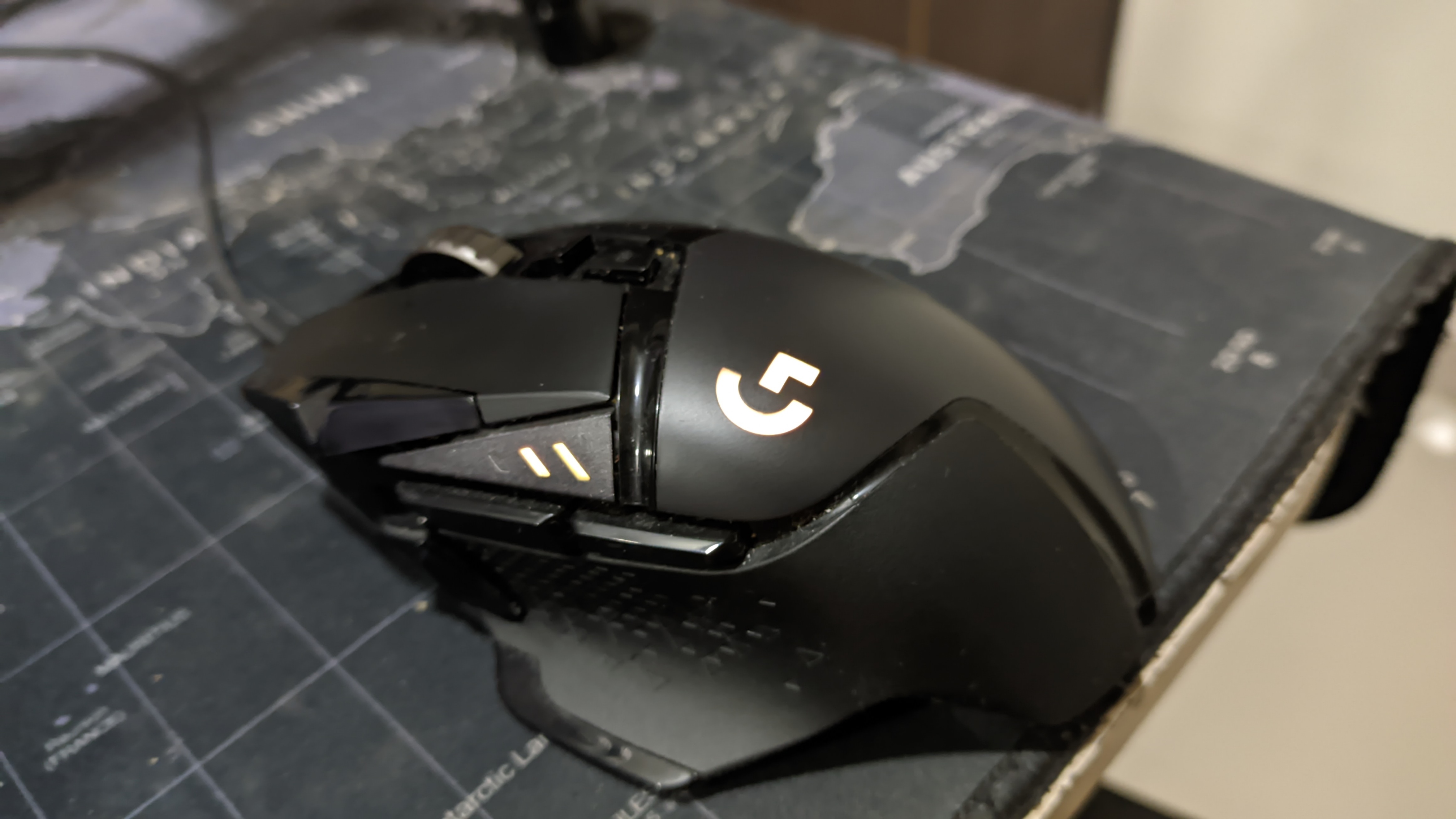 Black wired Logitech G502 HERO on a mouse mat