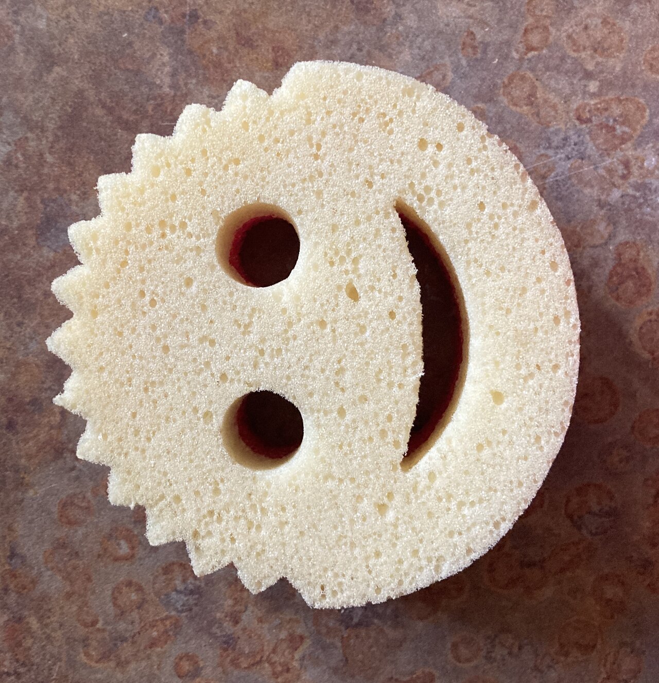 Photograph of a single pale-yellow Scrub Daddy sponge