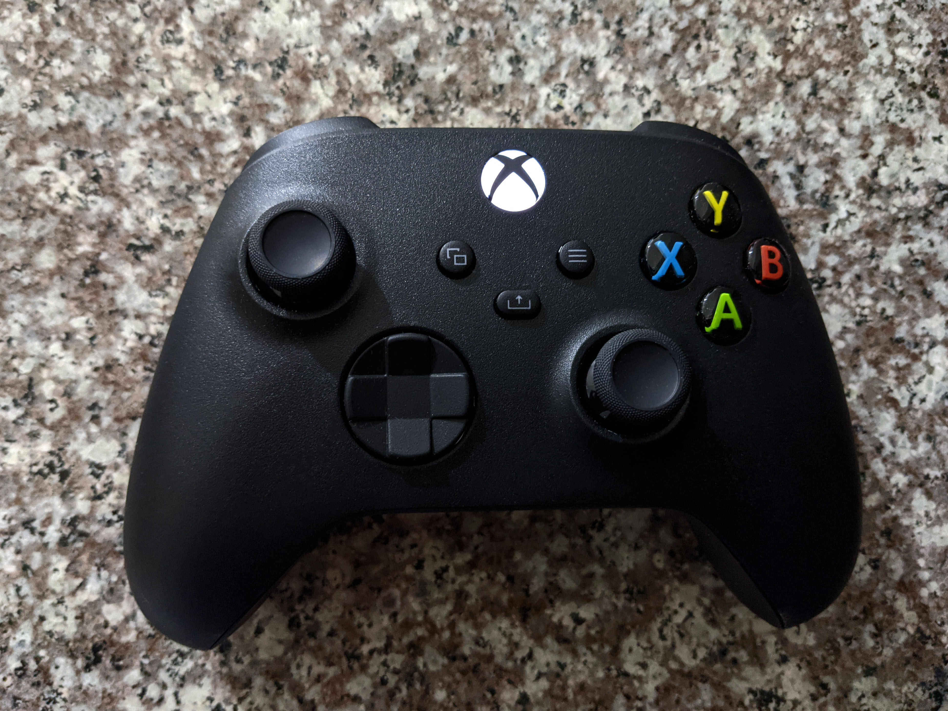 Carbon Black Xbox Series-generation wireless controller photographed on stone